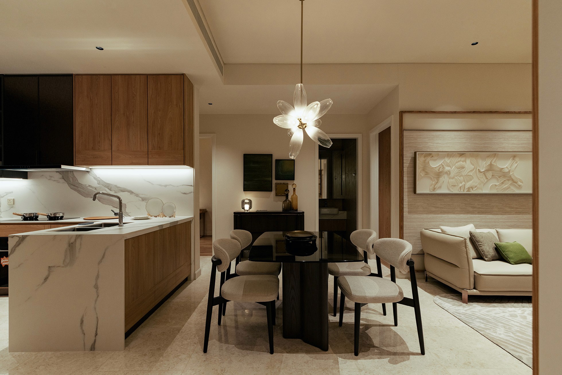 Dining area with sculptural pendant light beside the open kitchen — The Westin Residences show unit